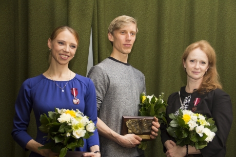 Pictured: Mr Trzensimiech holding a commemorative plaque flanked by Ms Dryl and Ms Kuskowska with medals pinned to their chests, all holding flowers