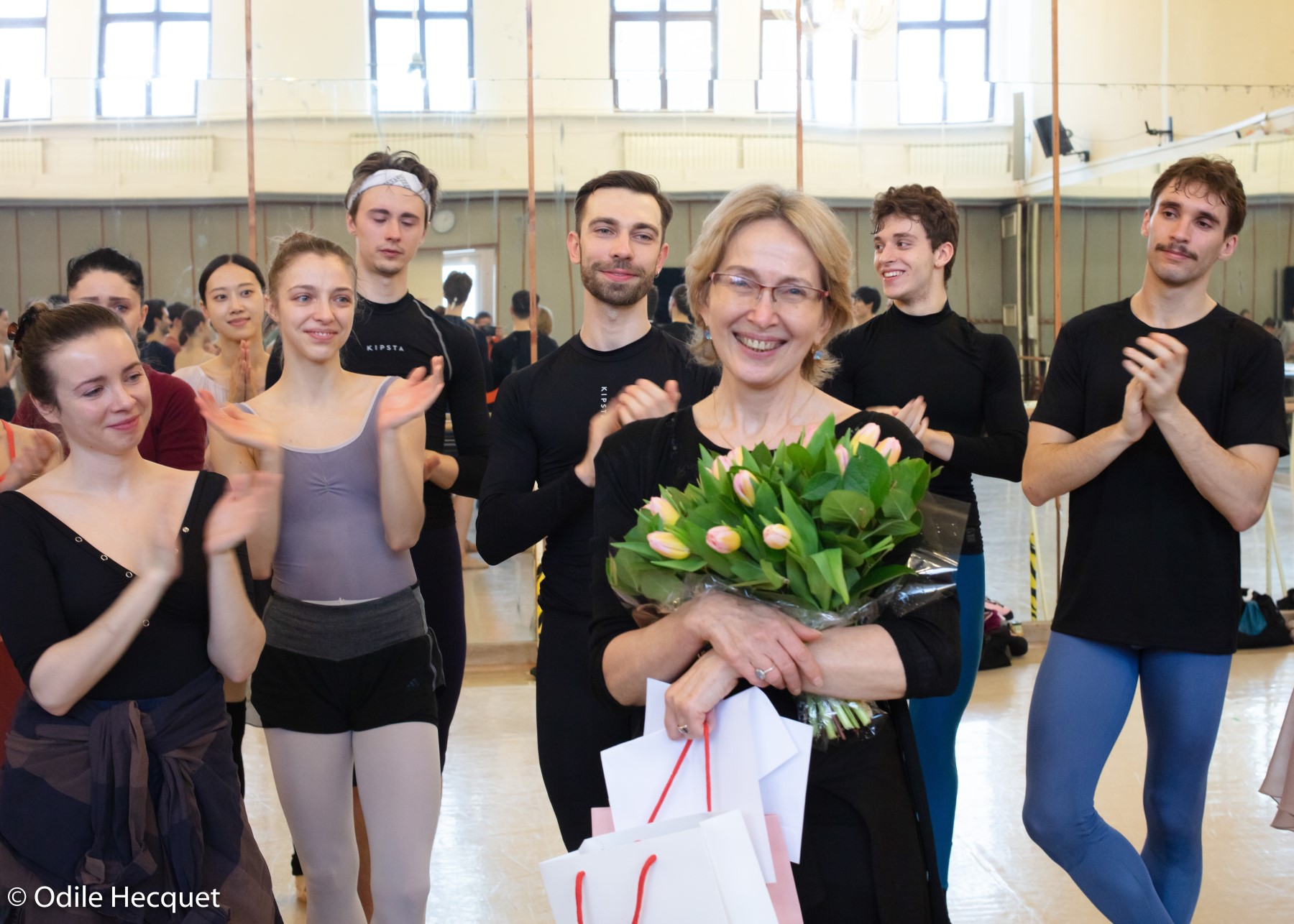 grupa klaszczących tancerzy, a pośrodku Kalina Schubert z kwiatami