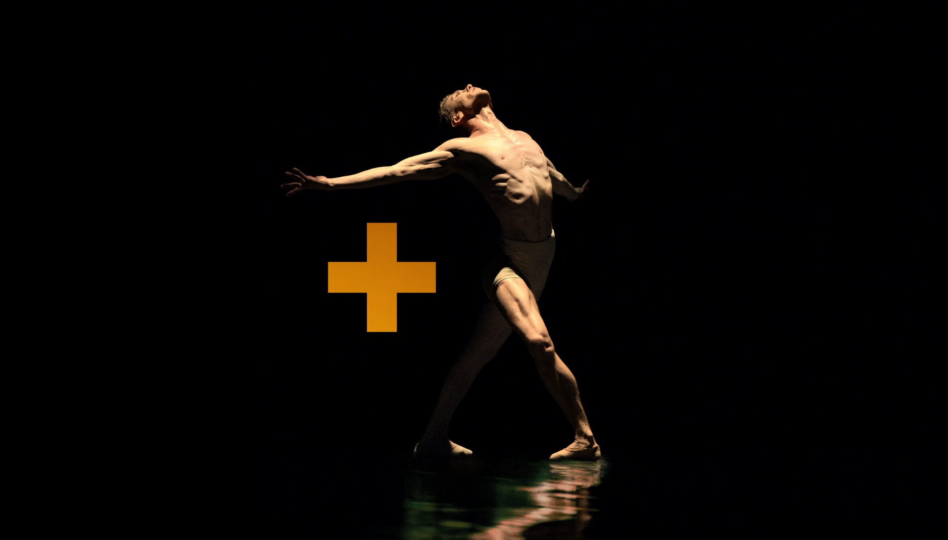 Tancerz w pozie na czarnym tle obok znaku graficznego plusa